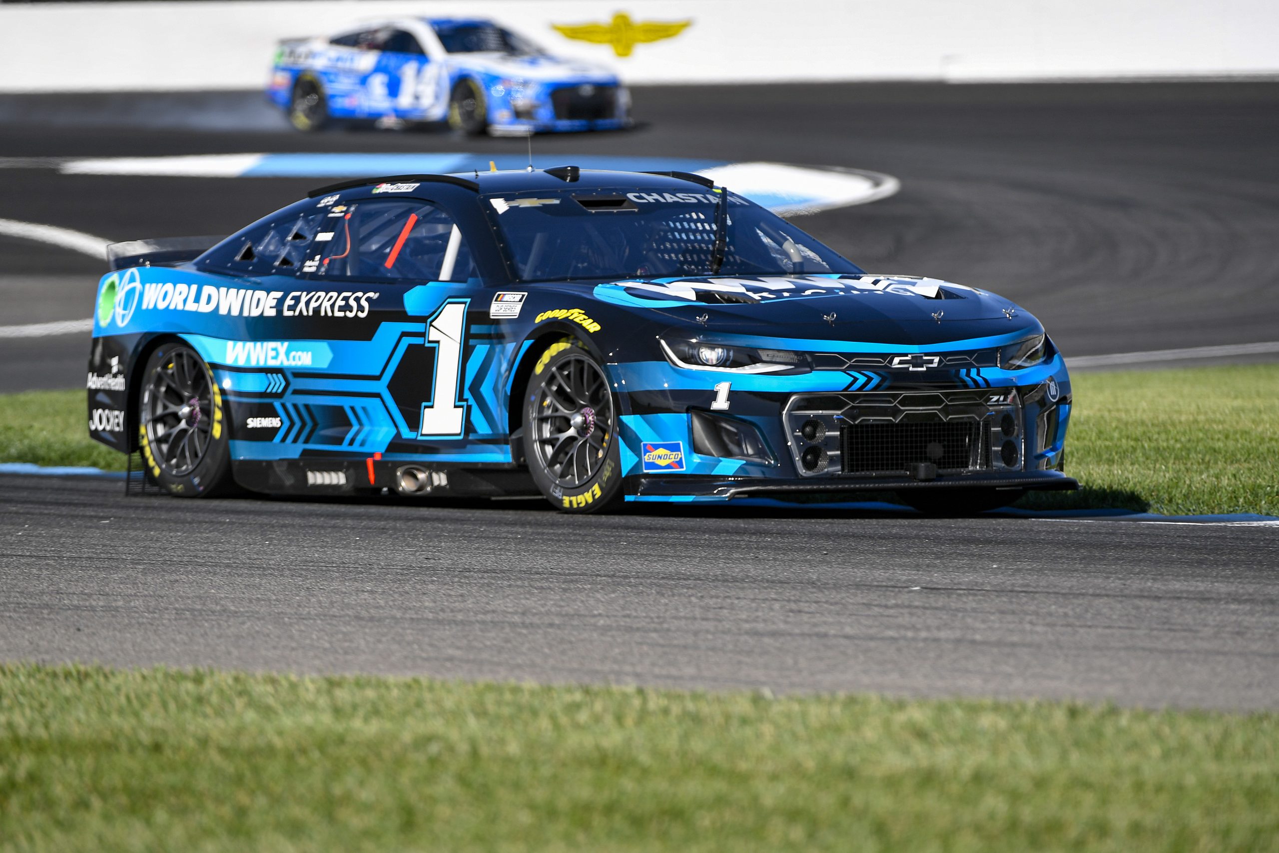 A blue race car driving down the track.