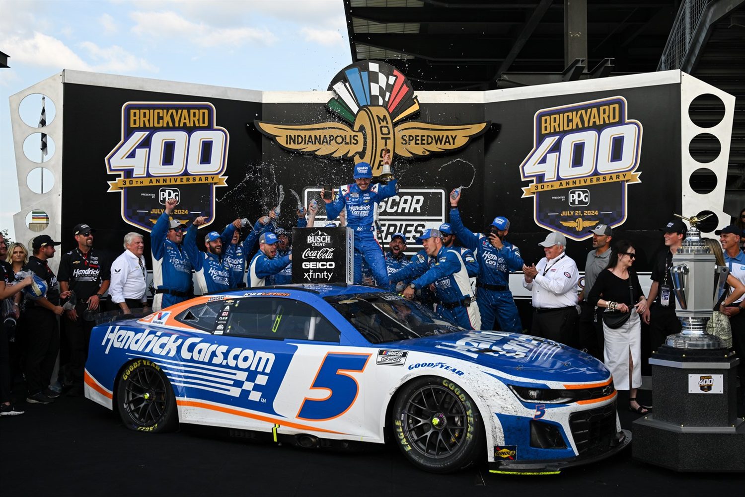 A group of people standing around a race car.
